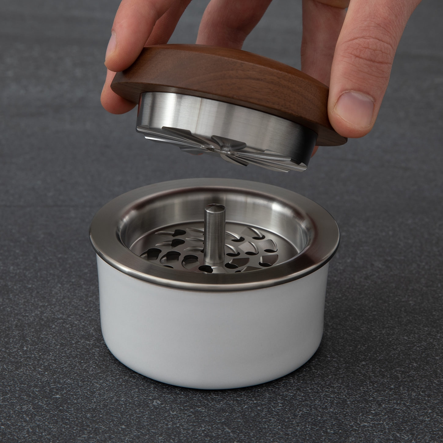 Hand lifting top on threadless contemporary walnut, porcelain, and stainless steel grinder with center shaft 
