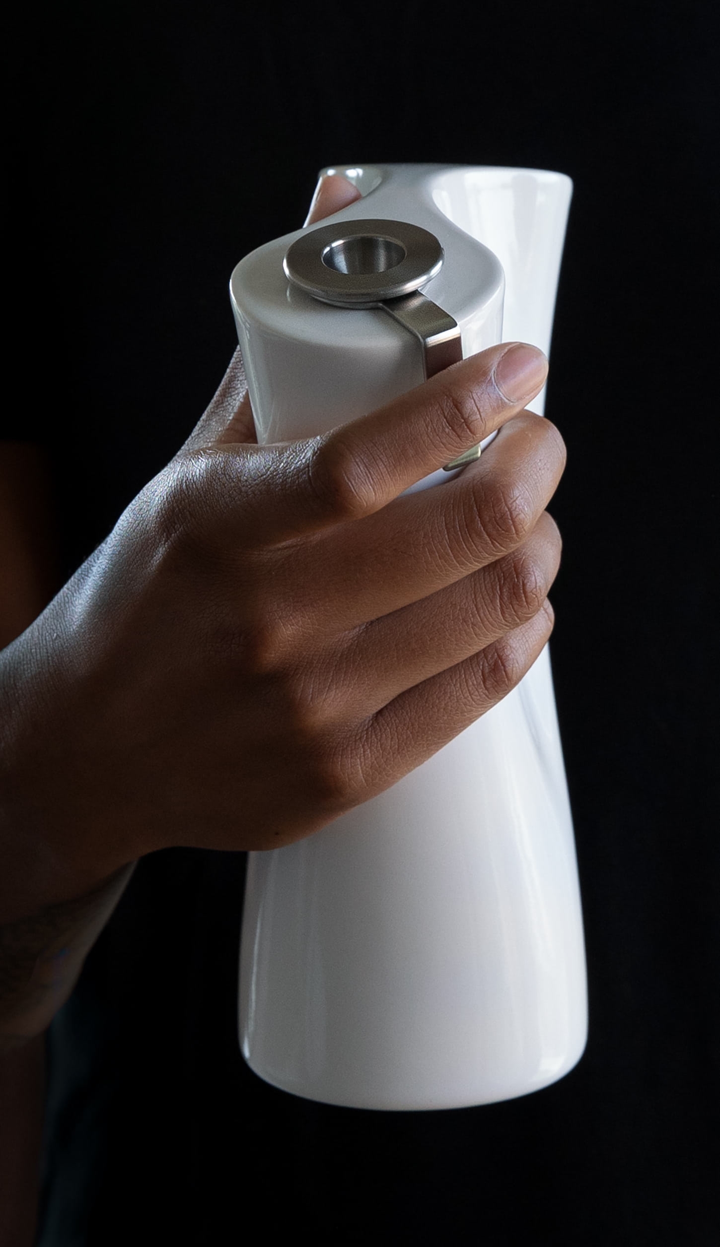 Women holding contemporary porcelain water pipe and pressing carb key