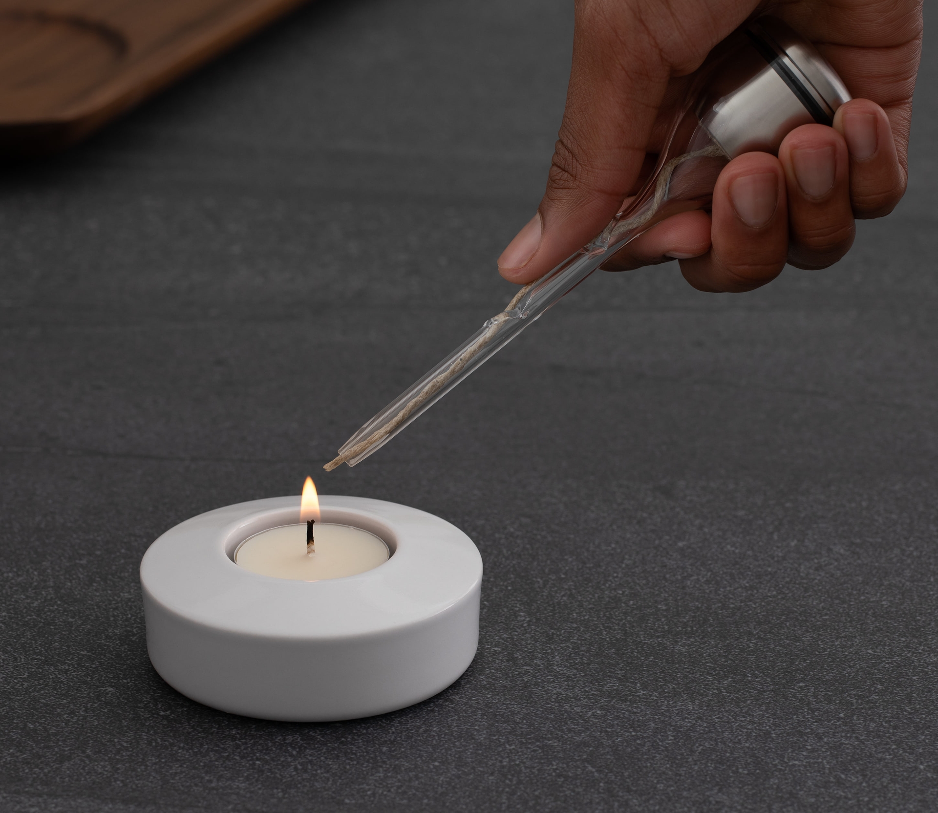 Lighting borosilicate glass wick holder on porcelain tealight 